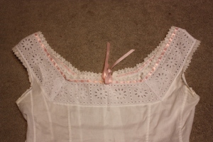 The finished neckline, showing the wide insertion lace with mitred corners.